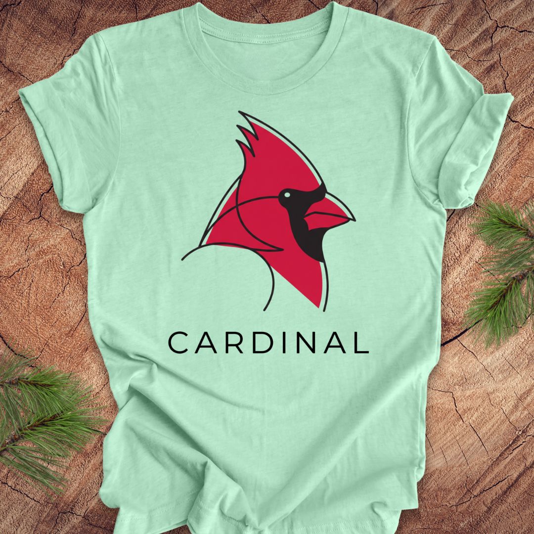 Mint green t-shirt with a cardinal and text on a wood background.