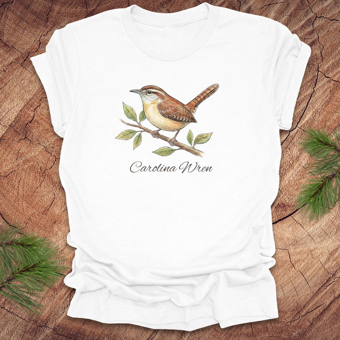 White t-shirt with a Carolina Wren illustration and text, 'carolina wren' on a wooden surface