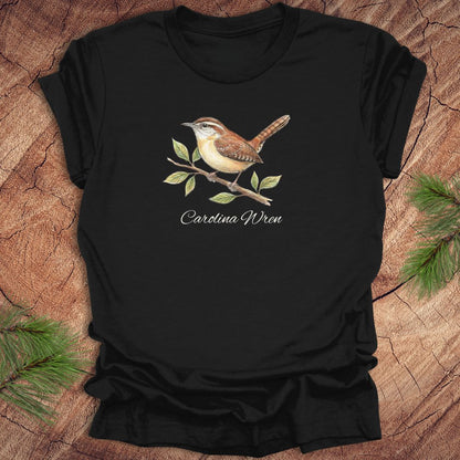 Black t-shirt with a Carolina Wren illustration and text, 'carolina wren' on a wooden surface
