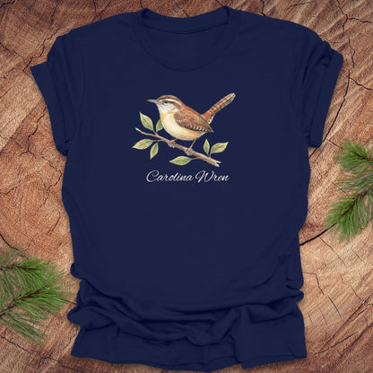 Navy blue t-shirt with a Carolina Wren illustration and text, 'carolina wren' on a wooden surface