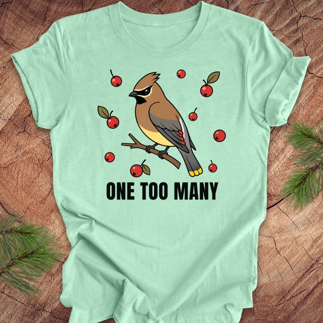 Mint green t-shirt with a cedar waxwing bird and berry design on a wooden surface