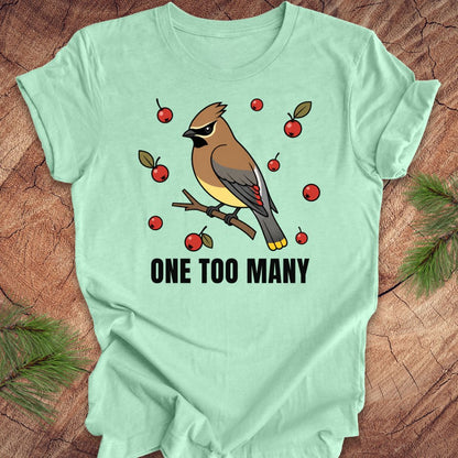 Mint green t-shirt with a cedar waxwing bird and berry design on a wooden surface