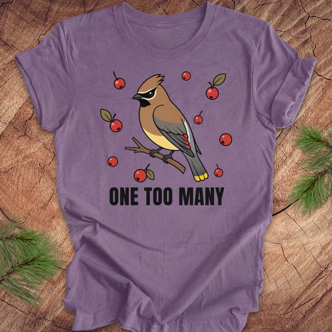 Purple t-shirt with a cedar waxwing bird and berry design on a wooden surface