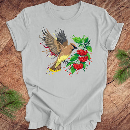 Gray t-shirt with a cedar waxwing bird and berry design on a wooden surface