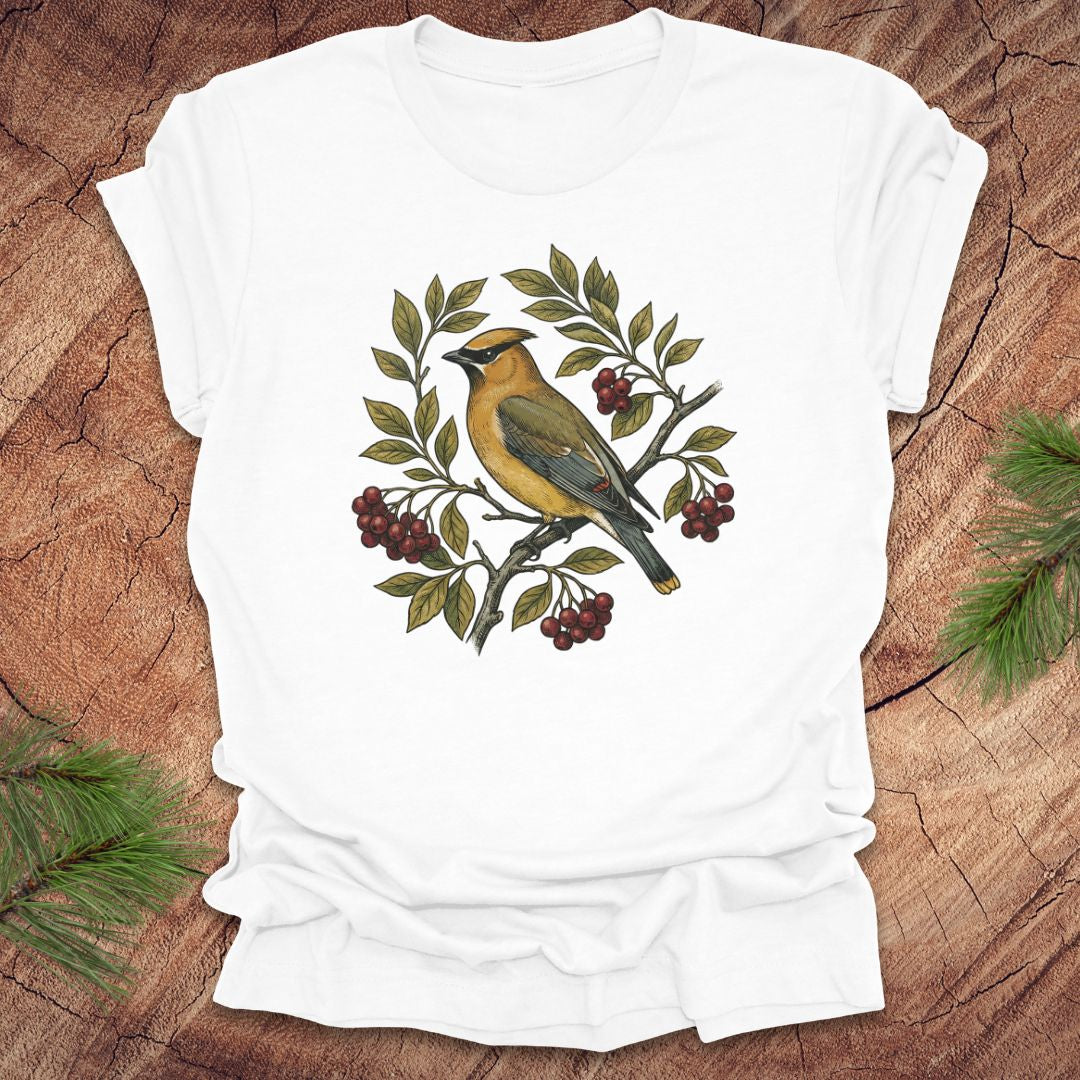 White t-shirt with a cedar waxwing bird and leaf design on a wooden surface