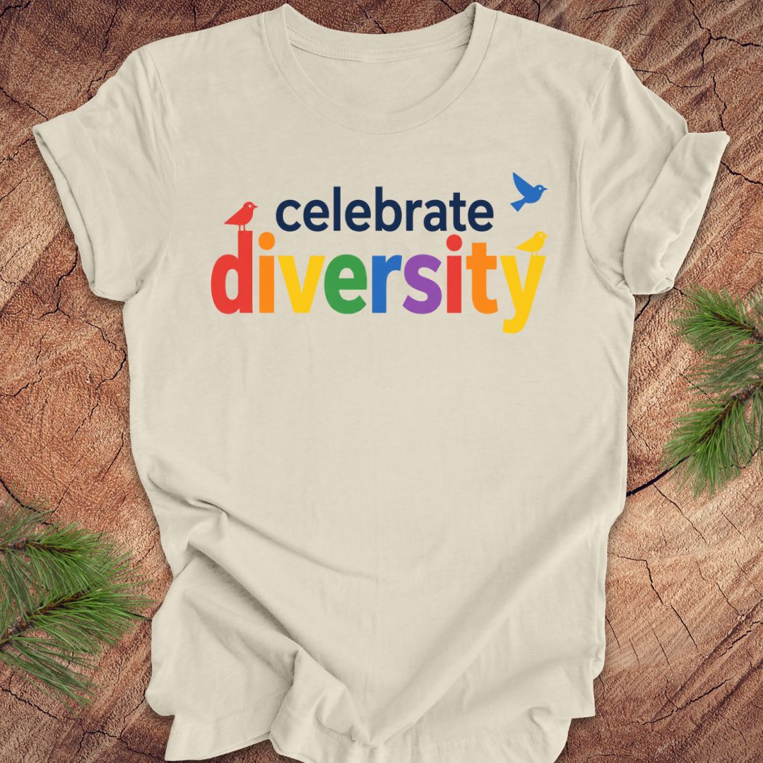 Beige t-shirt with 'celebrate diversity' text in colorful letters on a wooden surface.