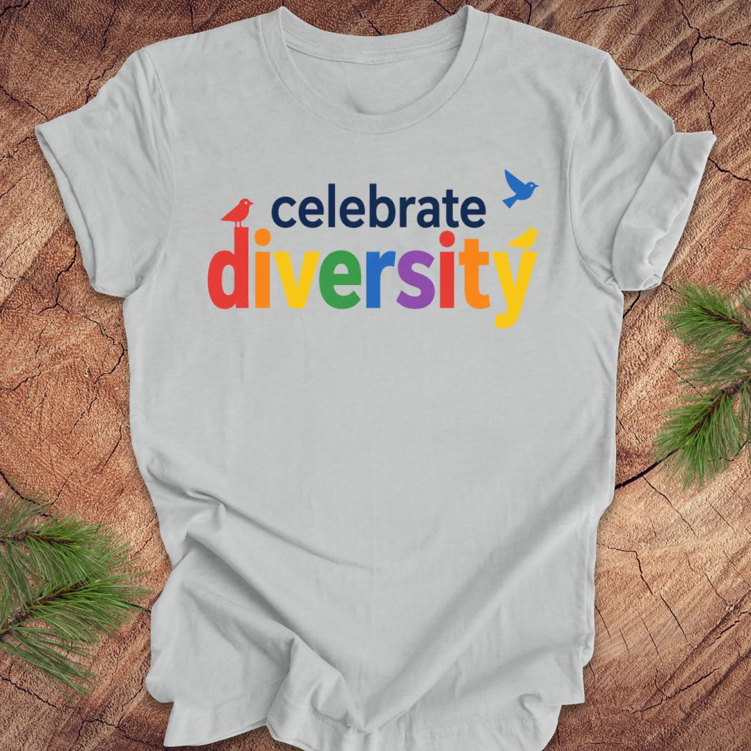 Gray t-shirt with 'celebrate diversity' text in colorful letters on a wooden surface.