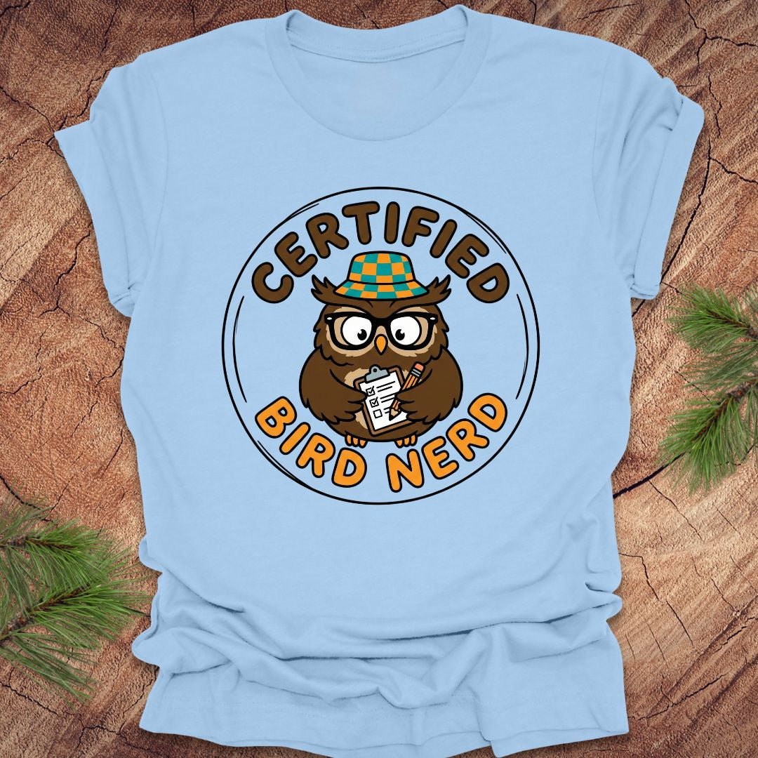 Light blue t-shirt with a 'Certified Bird Nerd' owl graphic on a wooden surface.