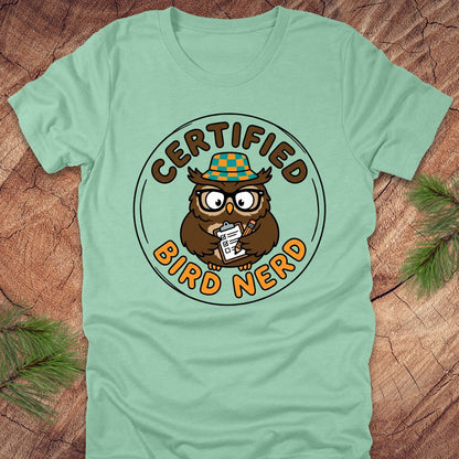 Light green t-shirt with owl graphic and 'Certified Bird Nerd' text on a wooden surface.