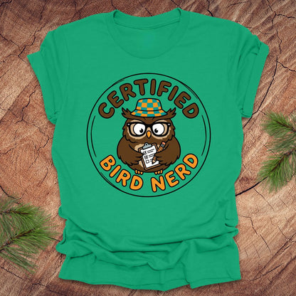 Green t-shirt with owl graphic and 'Certified Bird Nerd' text on a wooden surface.
