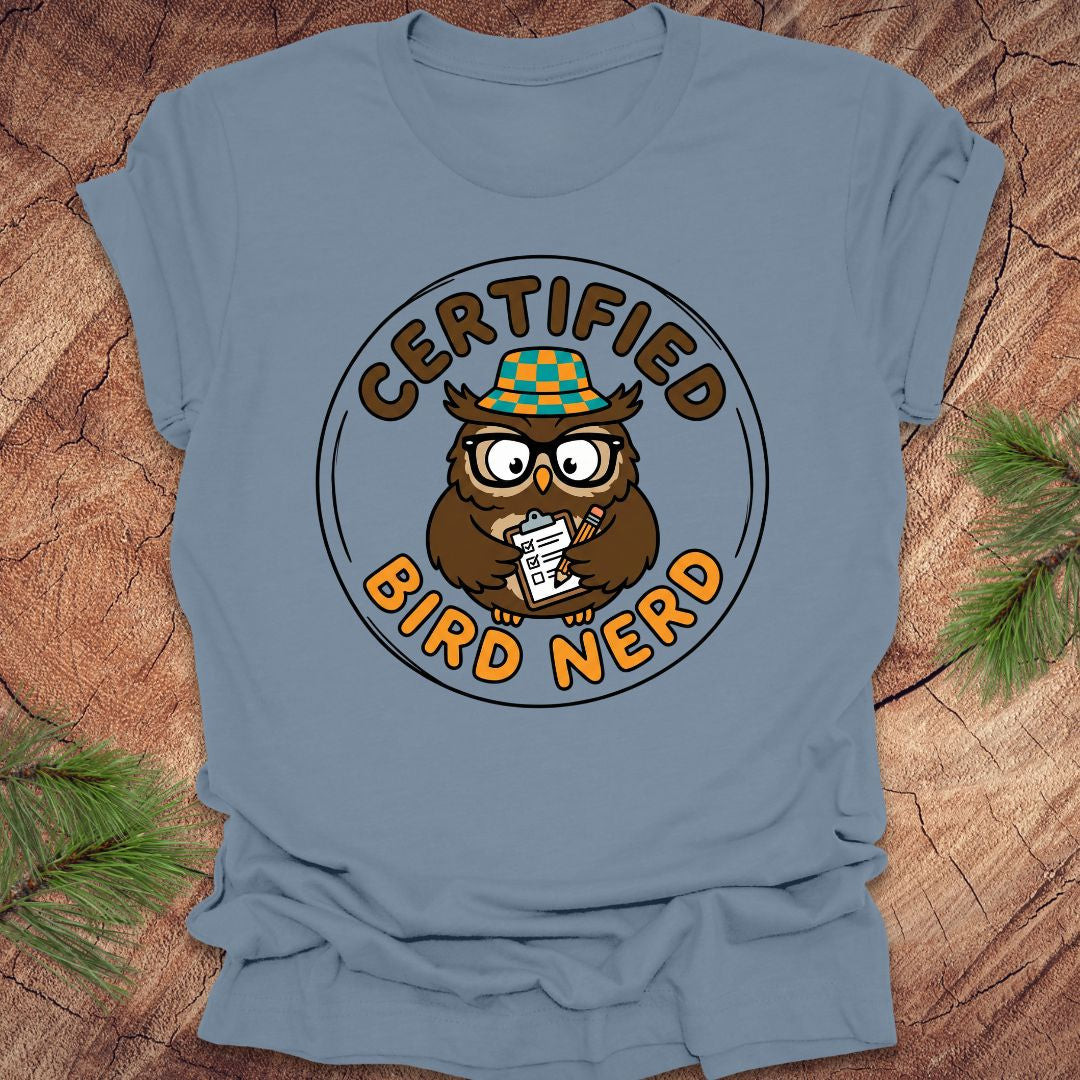 Blue t-shirt with an owl graphic and 'Certified Bird Nerd' text on a wooden surface.