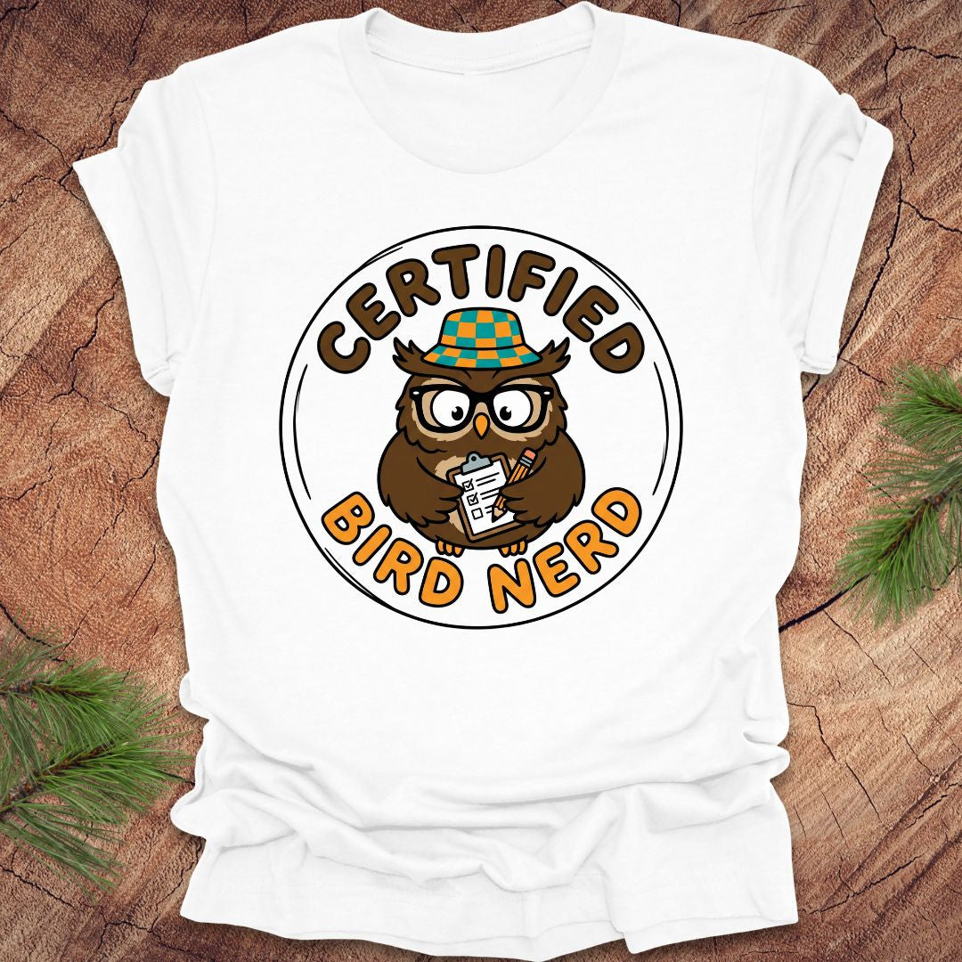 White t-shirt with an owl graphic and 'Certified Bird Nerd' text on a wooden surface.