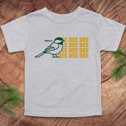 Gray toddler tshirt with a chickadee design and text on a wood background.