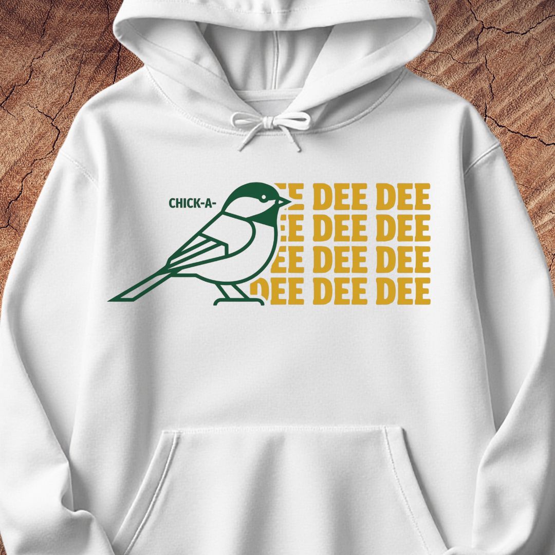 A white pullover hoodie with a graphic print featuring a green and white bird and the text 'CHICK-A-DEE DEE DEE DEE' in yellow, shown against a rustic wood background.