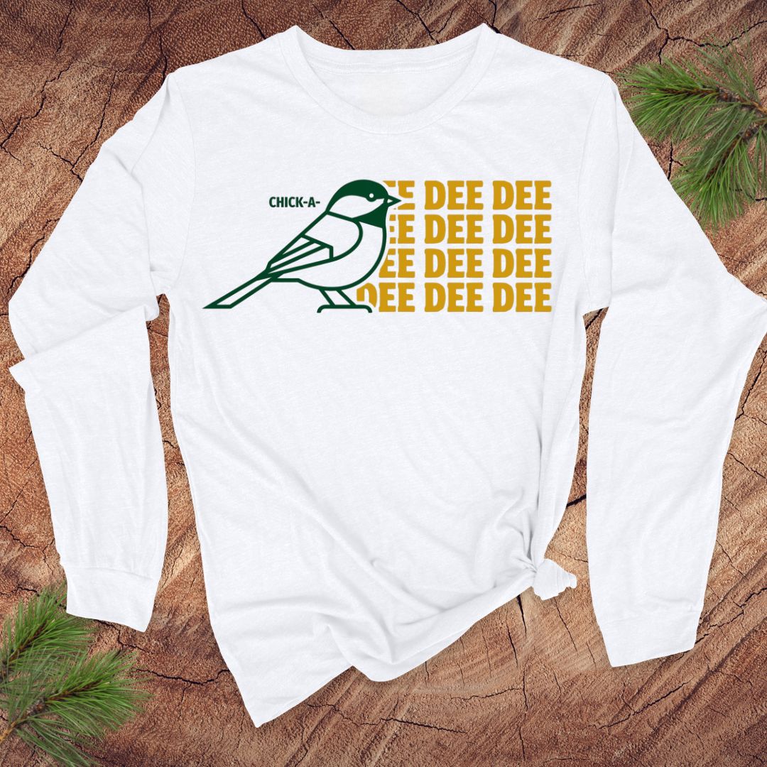 White long-sleeve shirt with a chickadee graphic and 'DEE DEE DEE' text on a wooden surface.