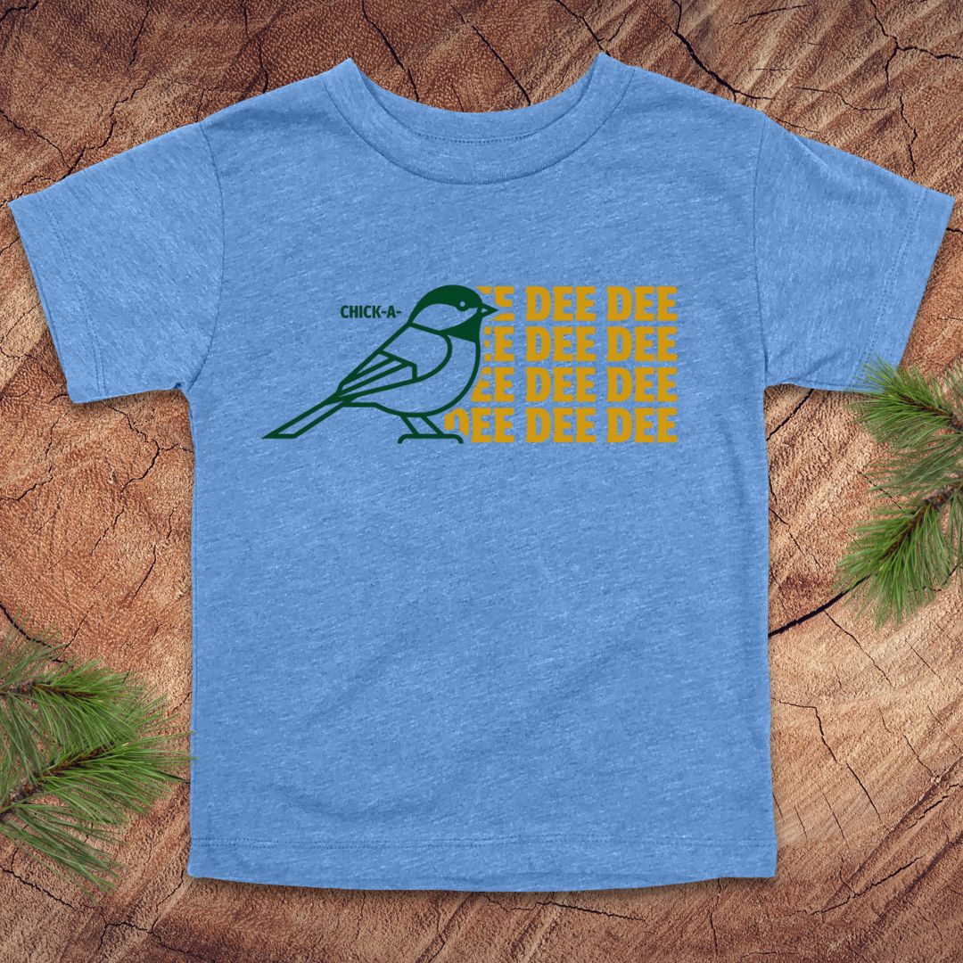 Blue toddler tshirt with a chickadee design and text on a wood background.