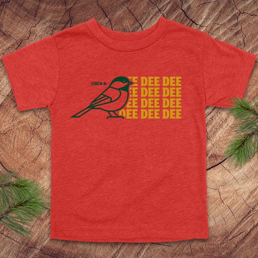 Red toddler tshirt with a chickadee design and text on a wood background.