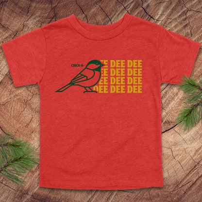 Red toddler tshirt with a chickadee design and text on a wood background.