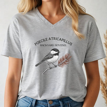 Person wearing a gray t-shirt with a chickadee illustration and scientific name text