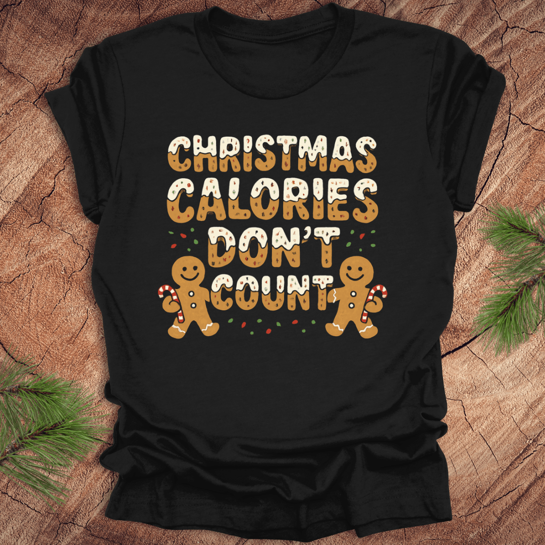Black tshirt with festive gingerbread text, 'Christmas calories don't count' with gingerbread men on a wooden background.