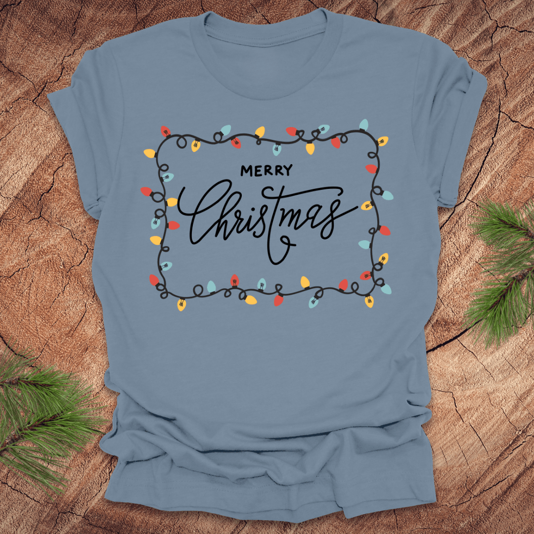 Steel blue t-shirt with christmas lights graphic and 'Merry Christmas' design on a wooden surface
