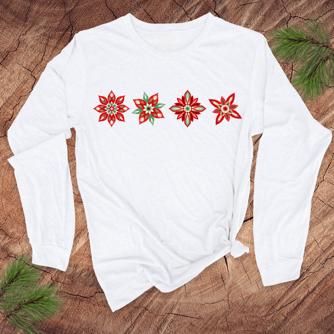 White long-sleeve shirt with red poinsettia designs on a wooden surface