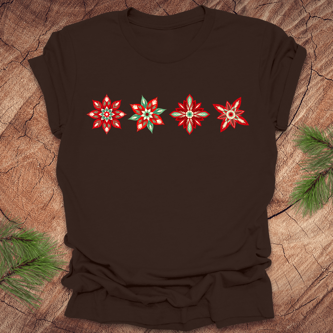Brown t-shirt with red and white poinsettia flower designs on a wooden surface