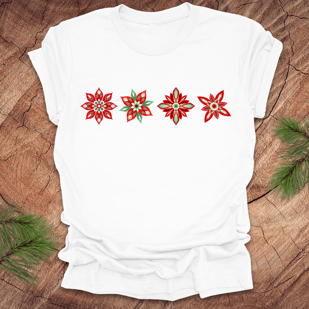 White t-shirt with red and white poinsettia flower designs on a wooden surface