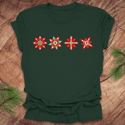 Dark green t-shirt with red and white poinsettia flower designs on a wooden surface