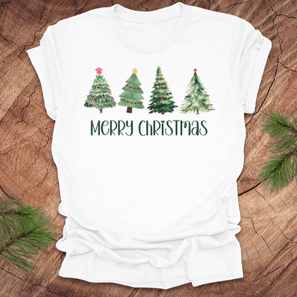 White tshirt with the text 'Merry Christmas' and christmas trees on a wood background.