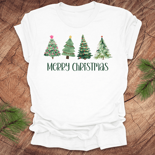 White tshirt with the text 'Merry Christmas' and christmas trees on a wood background.