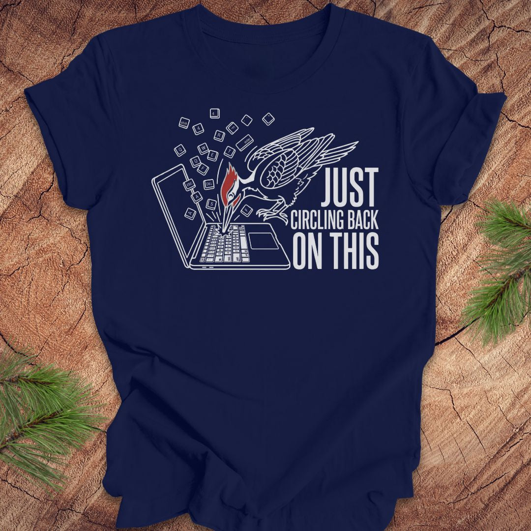 Navy blue t-shirt with a woodpecker graphic design and text on a wooden surface