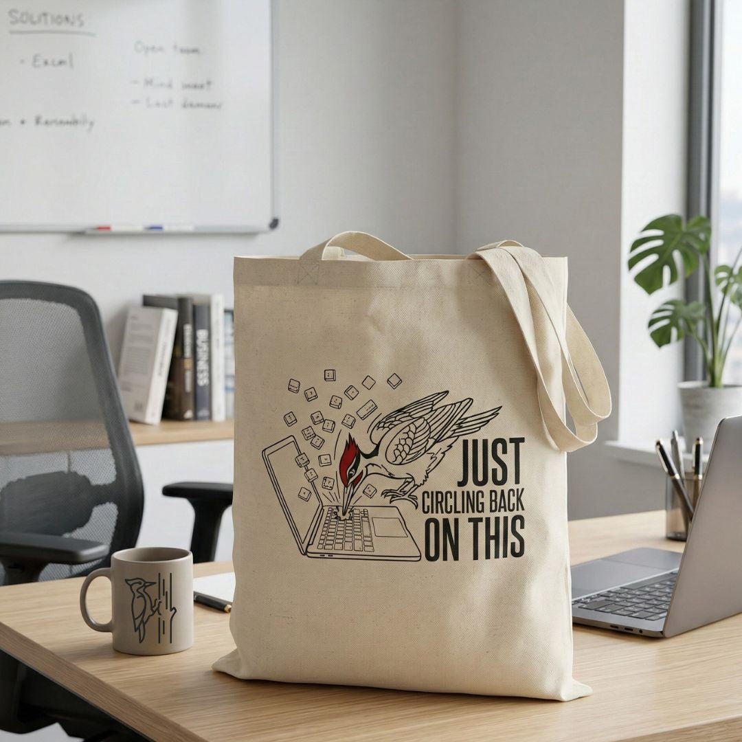 Tote bag with a woodpecker design and text 'just circling back on this' in an office setting.