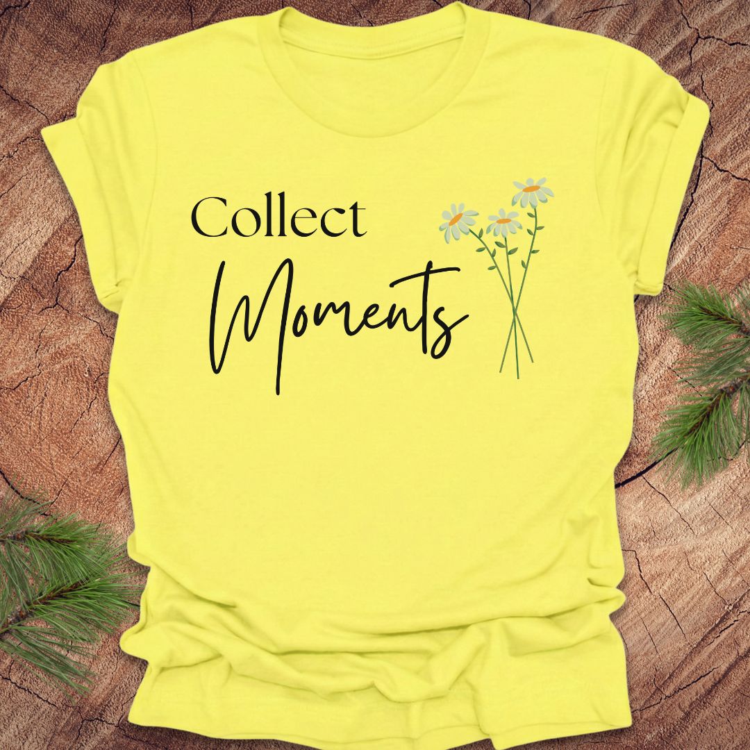 Yellow t-shirt with 'Collect Moments' text and daisy graphic on a wooden surface