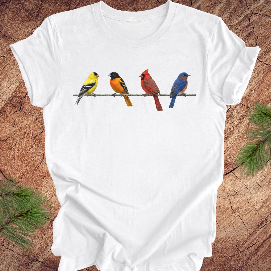 White t-shirt with colorful birds design on a wooden surface