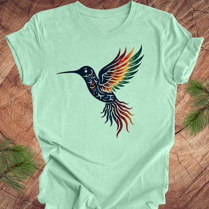 Light green t-shirt with a colorful hummingbird design on a wooden surface.