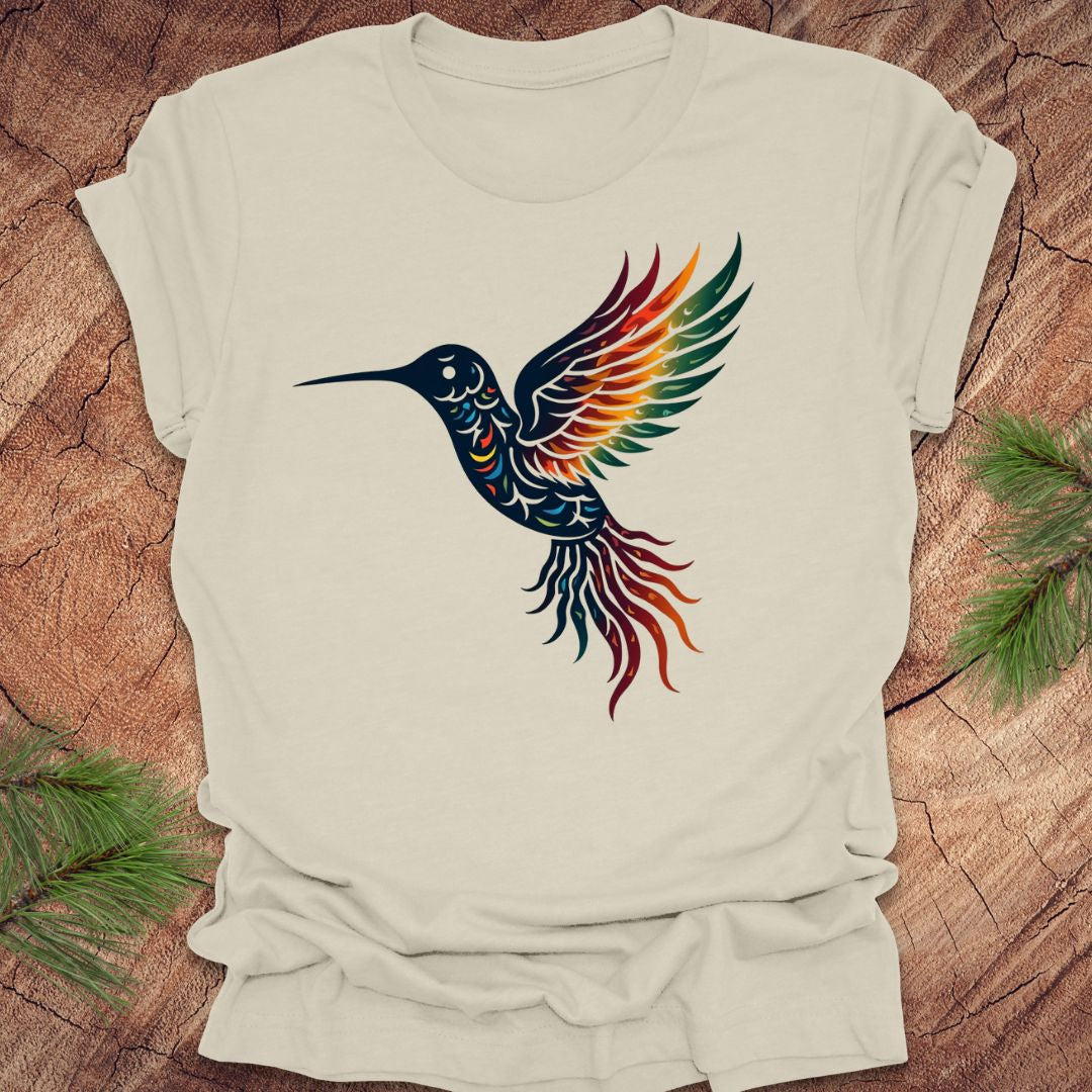 Beige t-shirt with a colorful hummingbird design on a wooden surface.
