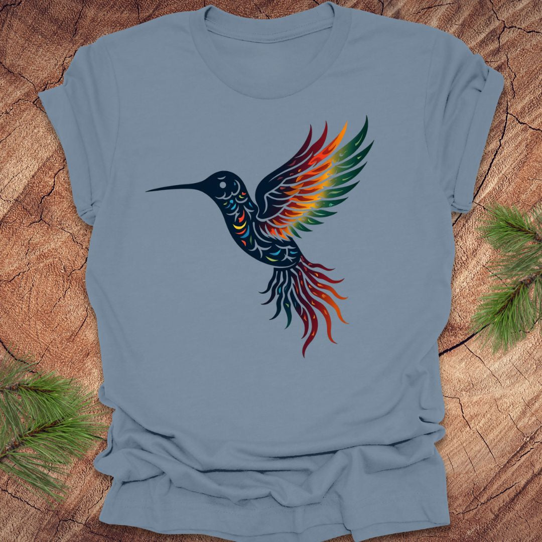 Blue t-shirt with a colorful hummingbird design on a wooden surface.
