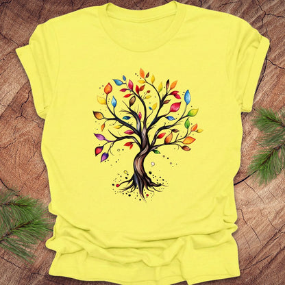 Yellow t-shirt with a colorful tree design on a wooden surface