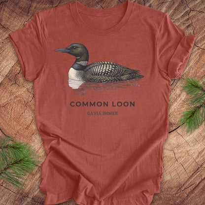 Clay colored t-shirt with a common loon on a wood background.
