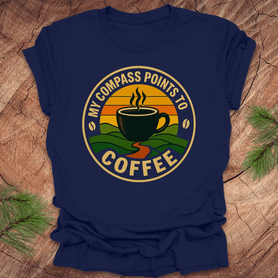 Navy blue t-shirt with a coffee-themed graphic and text, 'my compass points to coffee' on a wooden surface