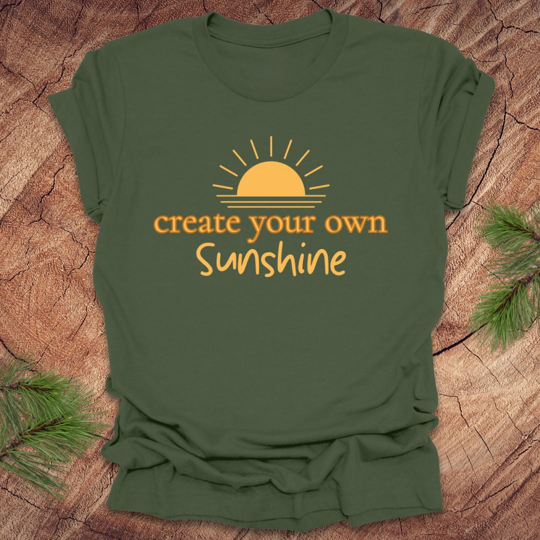 Green t-shirt with 'create your own Sunshine' text and sun graphic on a wooden surface.