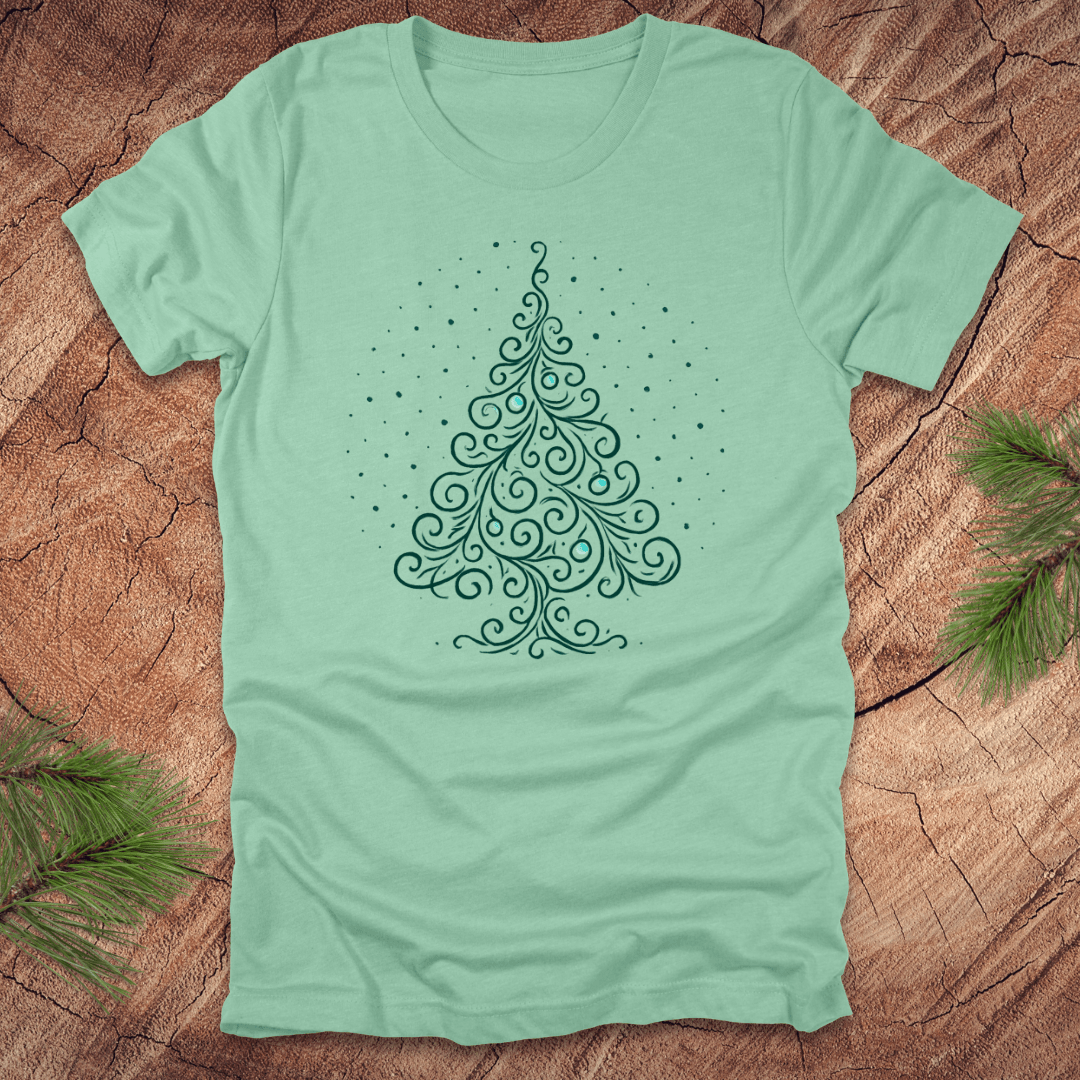Mint green t-shirt with a decorative Christmas tree design on a wooden surface.
