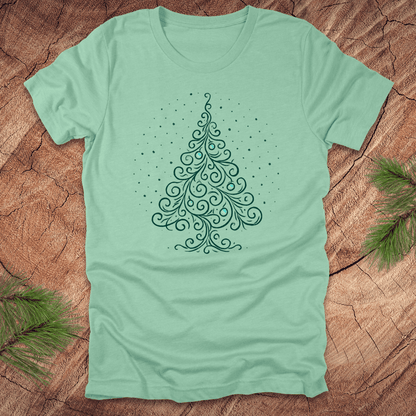 Mint green t-shirt with a decorative Christmas tree design on a wooden surface.