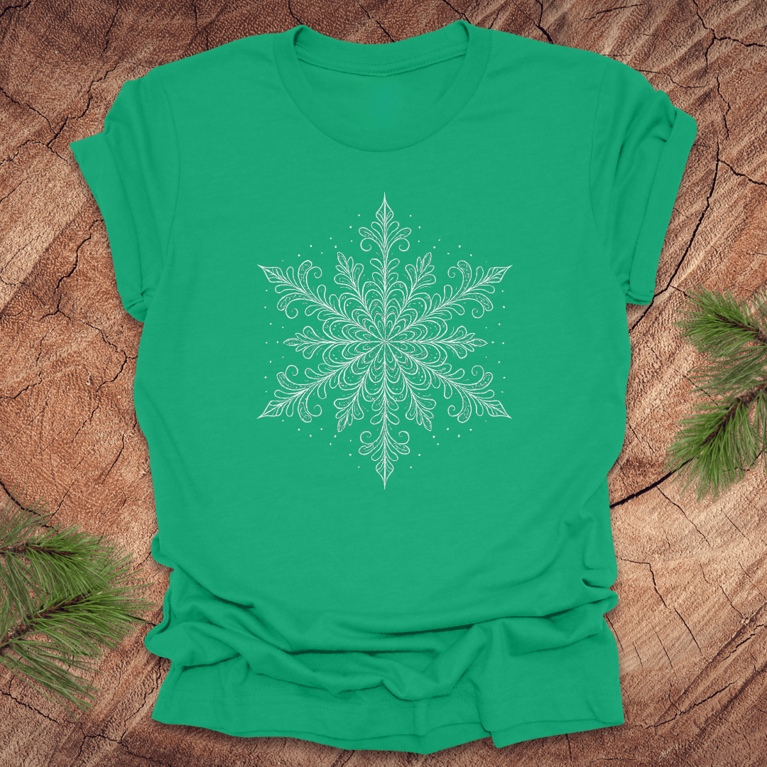 Green t-shirt with a white snowflake design on a wooden surface