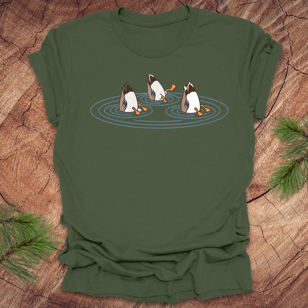 Green t-shirt with cartoon ducks dabbling on a pond design on a wooden surface
