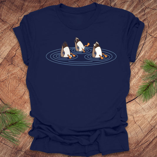 Navy blue t-shirt with cartoon ducks dabbling on a pond design on a wooden surface