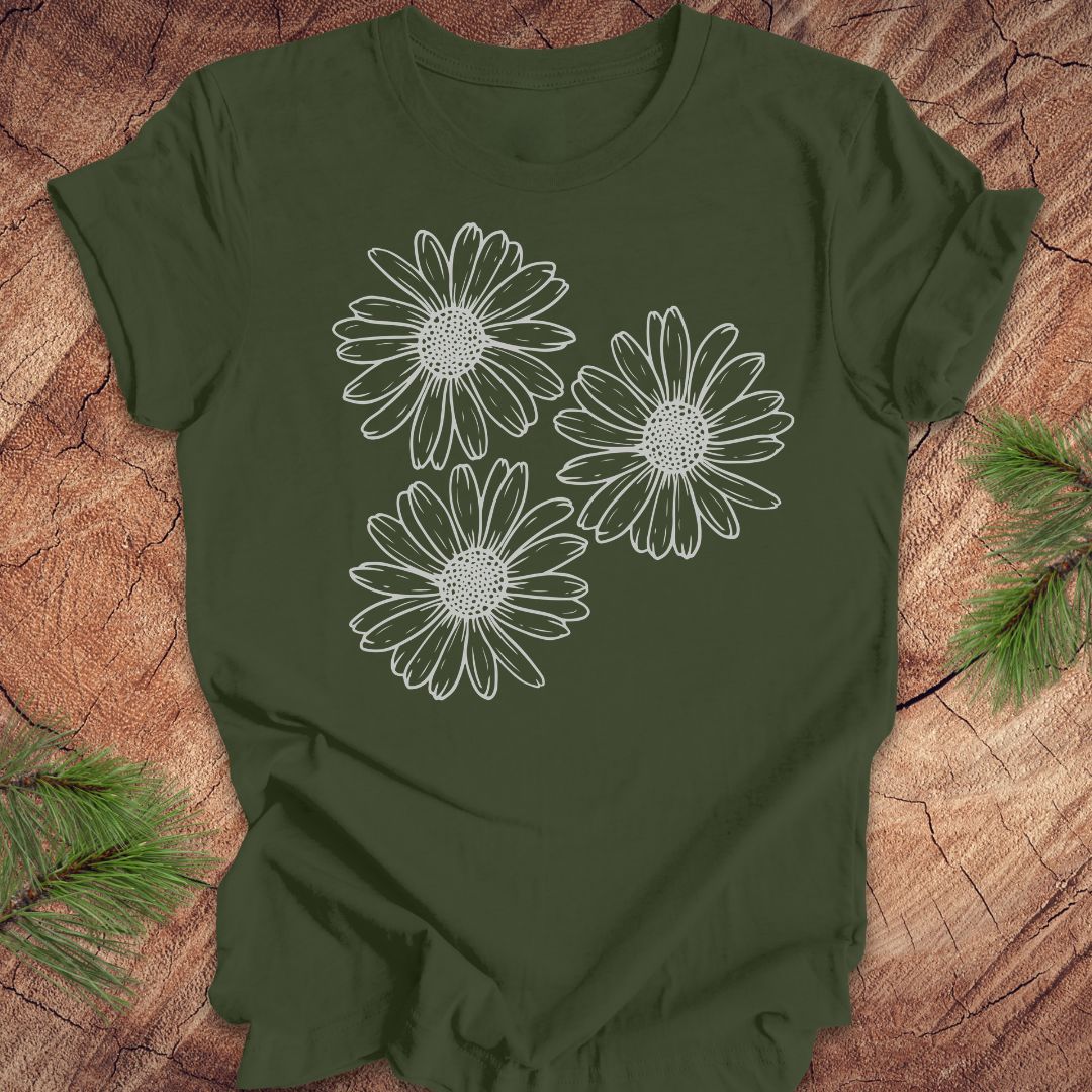 Green t-shirt with daisy designs on a wooden surface