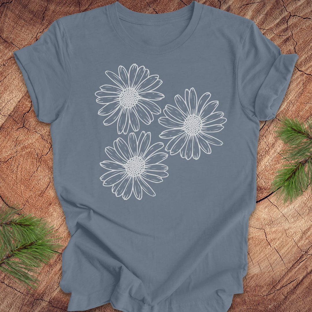 Blue t-shirt with daisy designs on a wooden surface