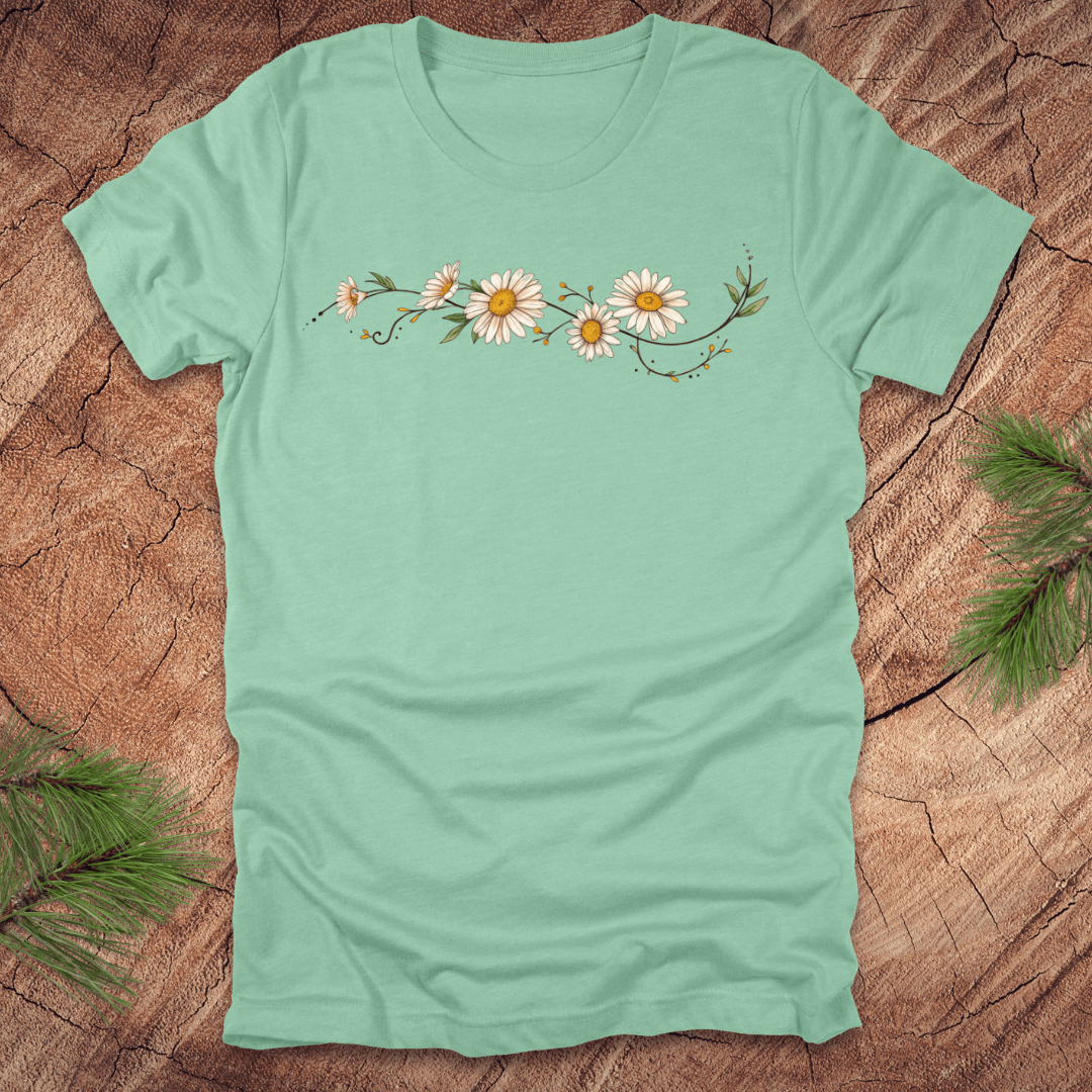 Mint green t-shirt with daisy design on a wooden surface
